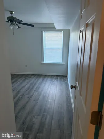 an empty room with wooden floor and a window