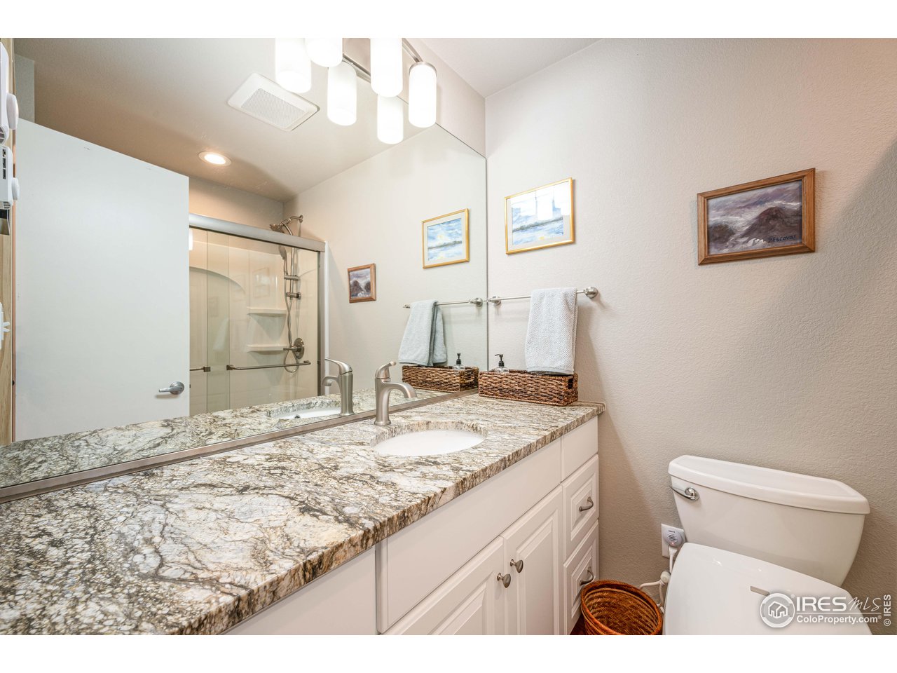 245 Hemlock Drive Lyons, CO 80540 - Photo 24 of 34 a bathroom with a granite countertop sink a toilet and a large mirror