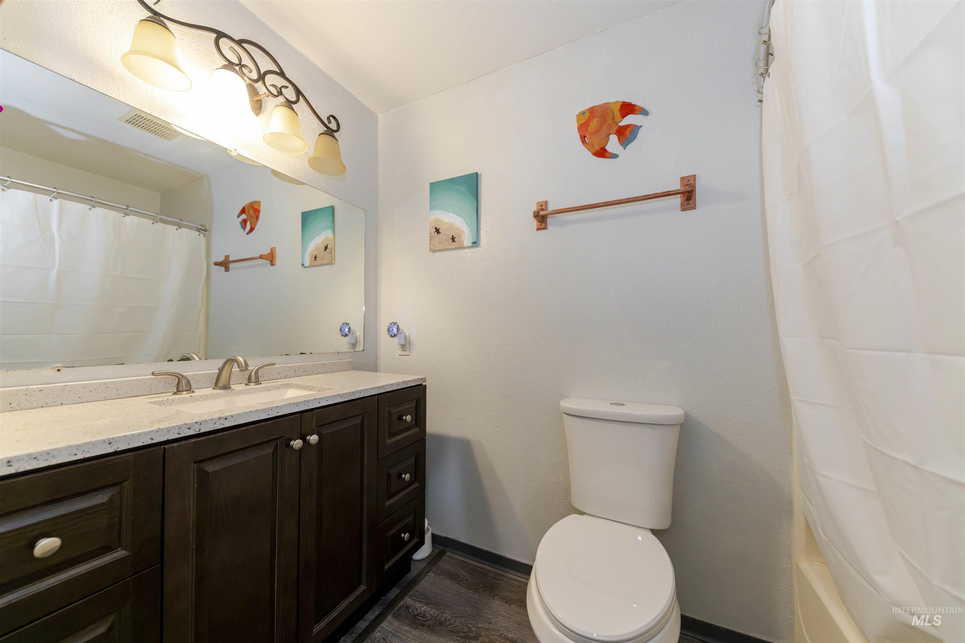 930 Preston Avenue Lewiston, ID 83501 - Photo 12 of 32 Bathroom featuring vanity, dark wood finished floors, and shower / tub combo with curtain