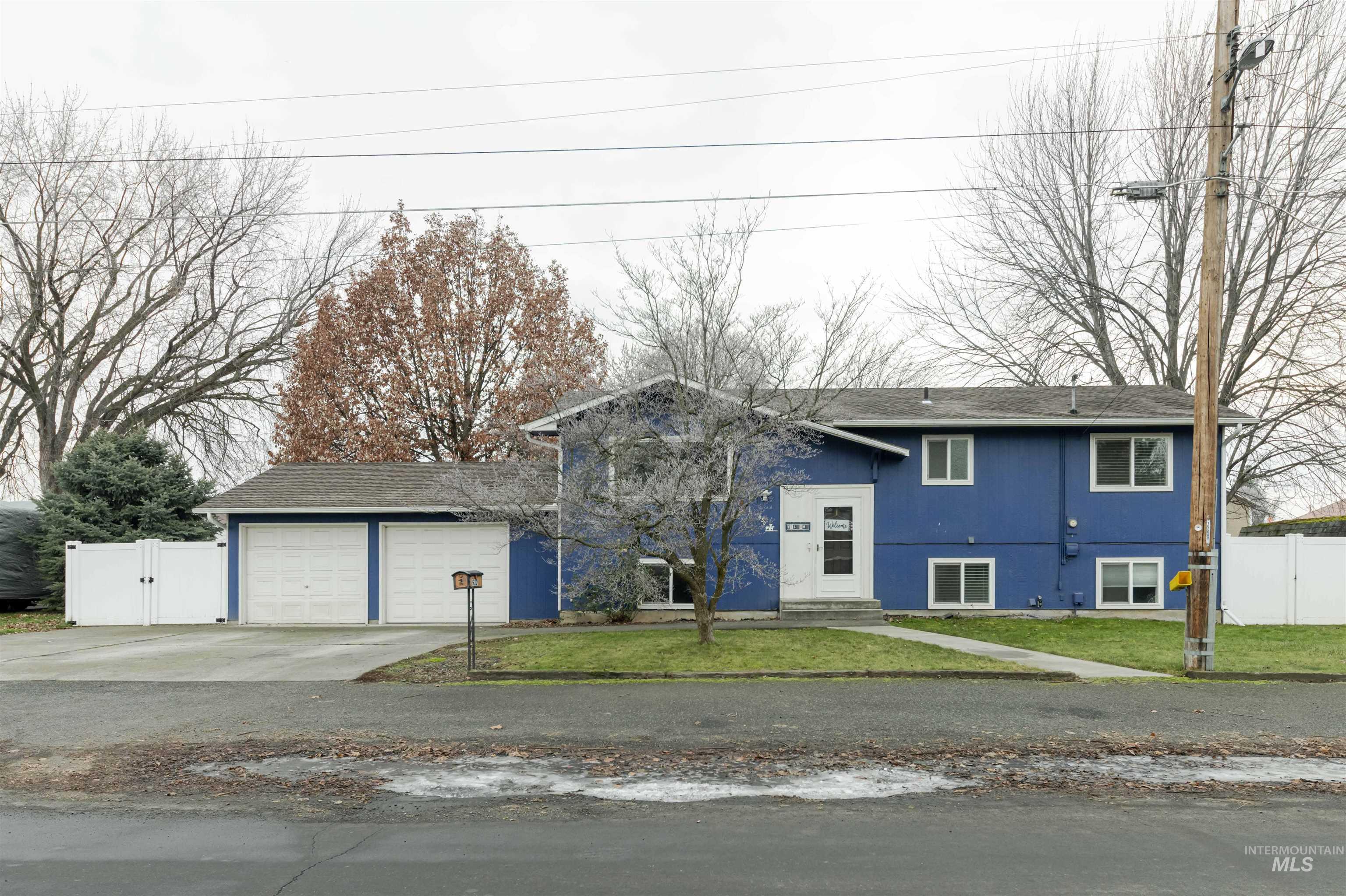 930 Preston Avenue Lewiston, ID 83501 - Photo 2 of 32 View of front of property with a gate, driveway, a garage, a shingled roof, and stucco siding