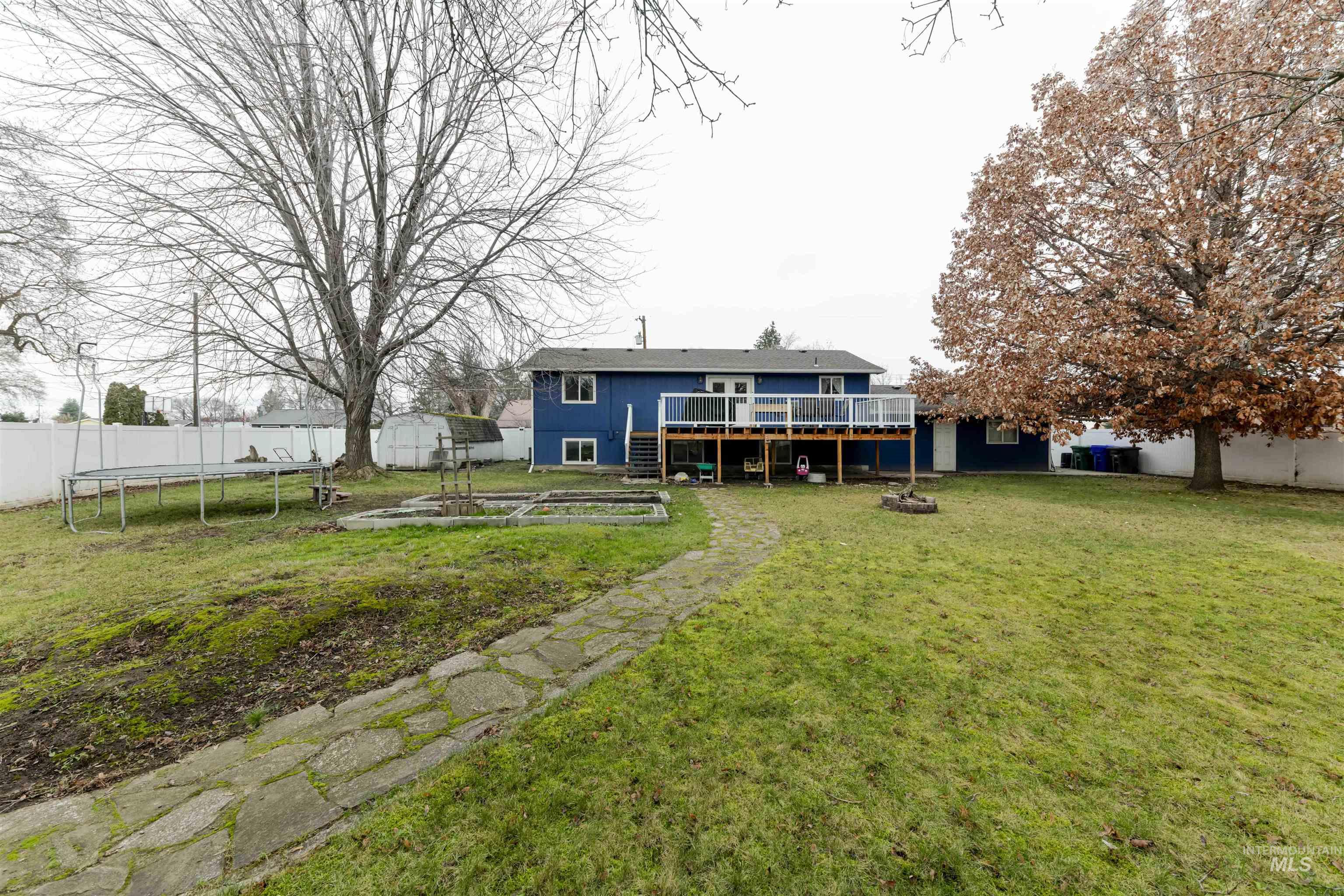 930 Preston Avenue Lewiston, ID 83501 - Photo 28 of 32 Back of property featuring a trampoline, a fire pit, a wooden deck, a garden, and stairway