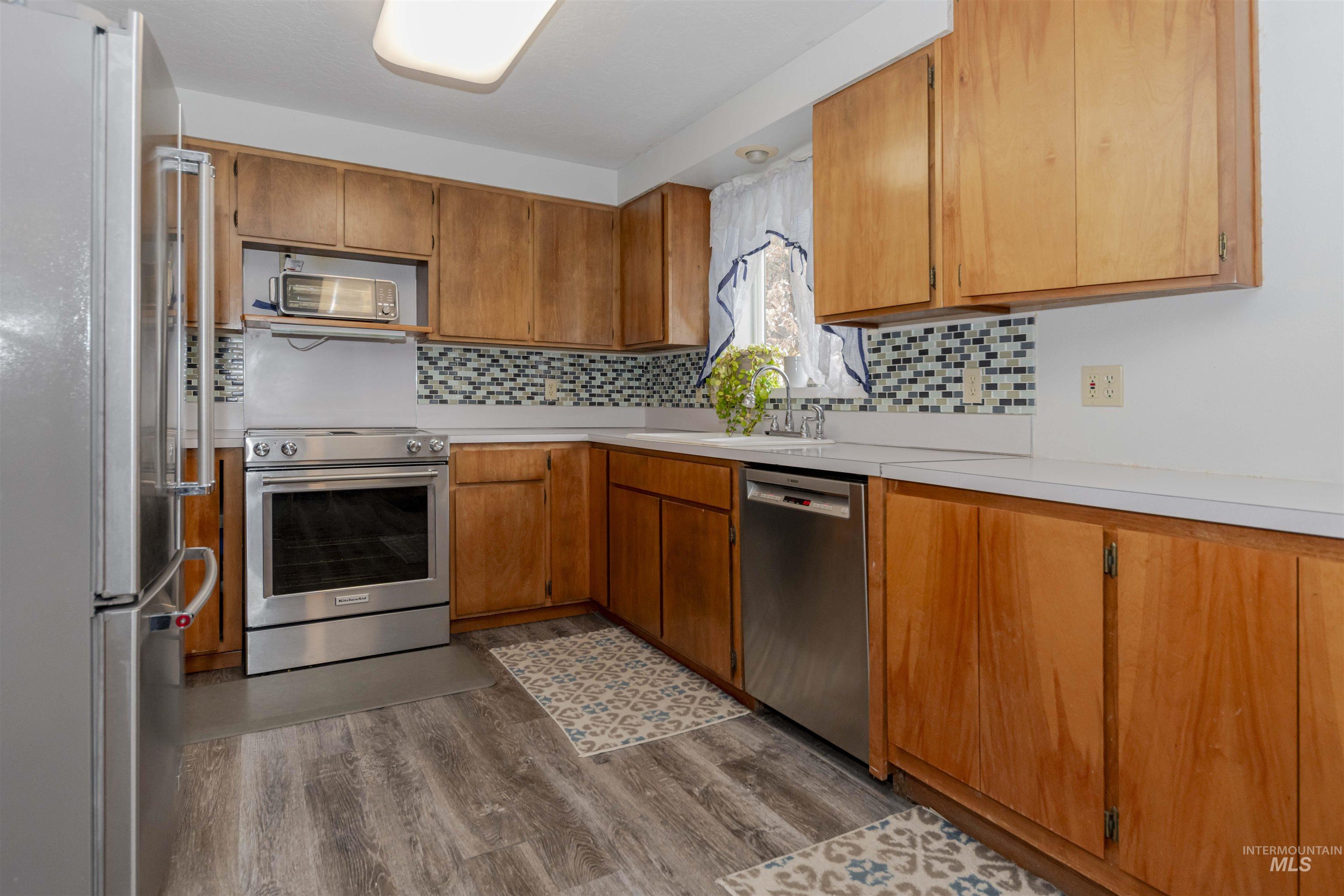 930 Preston Avenue Lewiston, ID 83501 - Photo 6 of 32 Kitchen with appliances with stainless steel finishes, light countertops, and brown cabinets