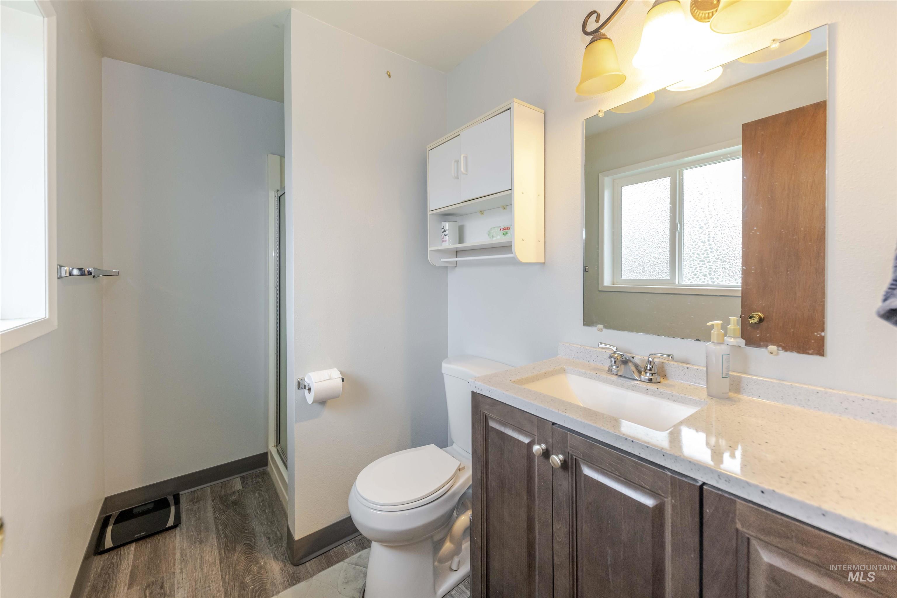 930 Preston Avenue Lewiston, ID 83501 - Photo 8 of 32 Full bath featuring vanity, a shower stall, and dark wood-style floors