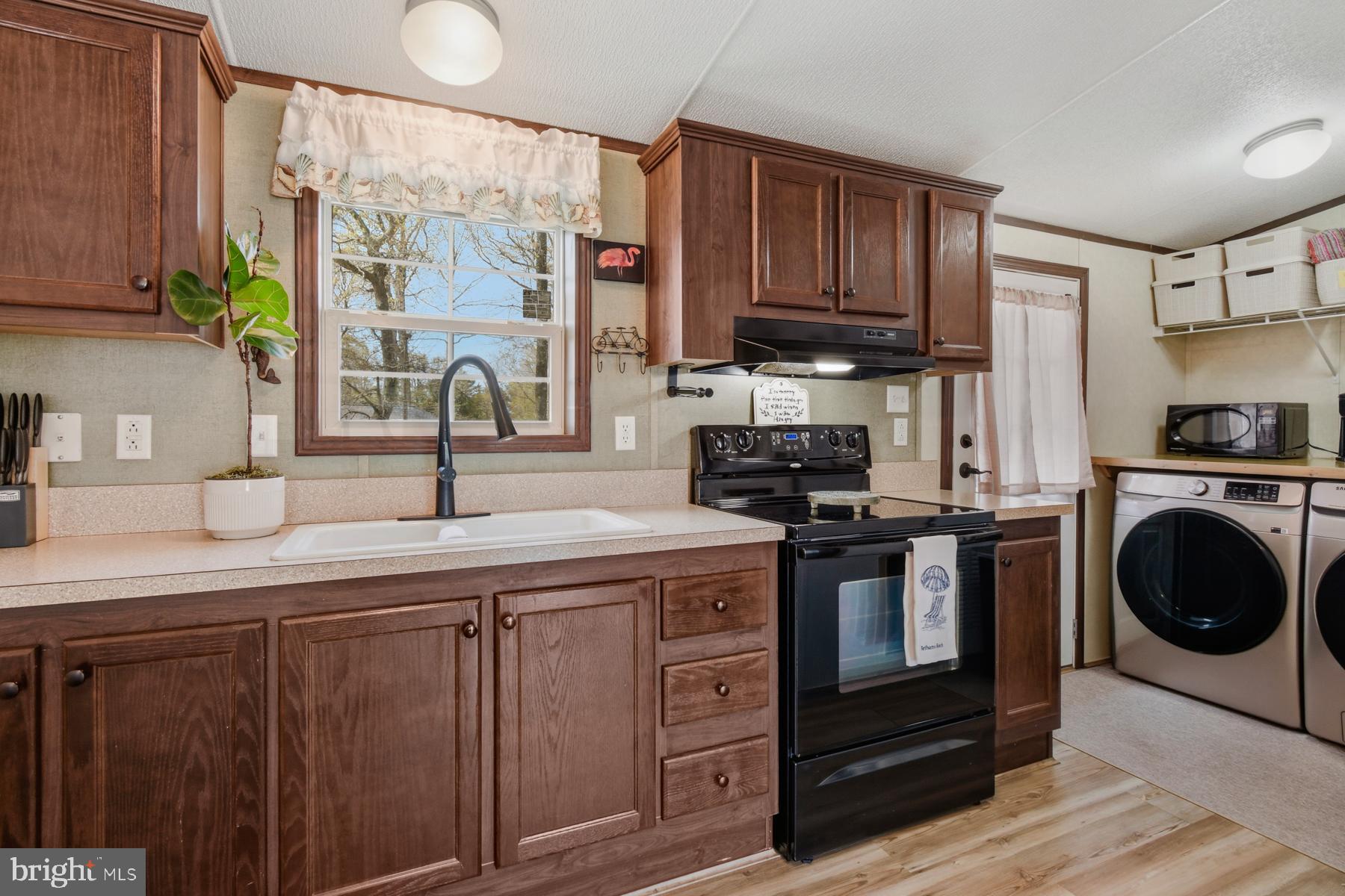 30837 West Lagoon Road Dagsboro, DE 19939 - Photo 19 of 42 a kitchen with stainless steel appliances granite countertop a sink a stove and cabinets