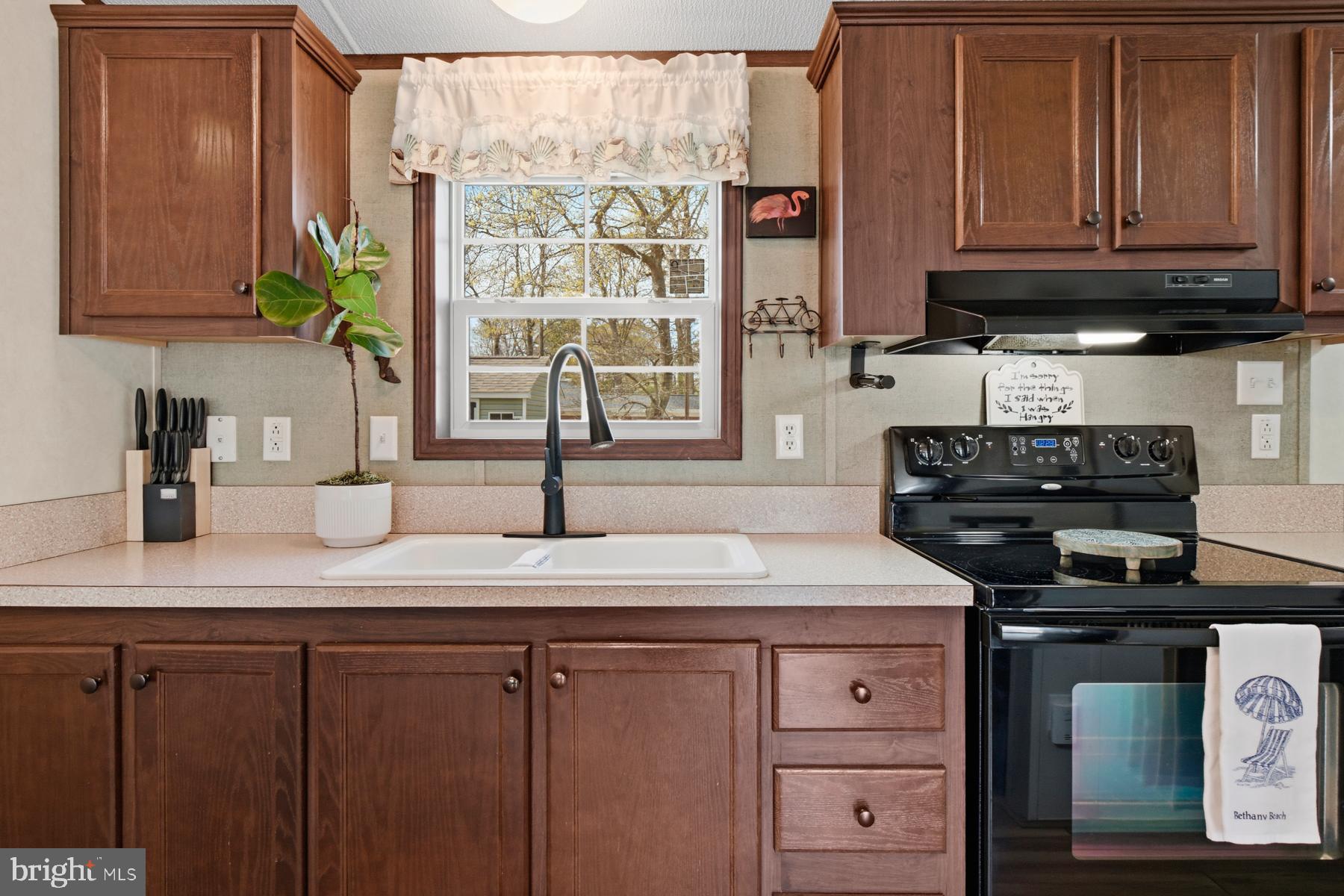 30837 West Lagoon Road Dagsboro, DE 19939 - Photo 20 of 42 a kitchen with stainless steel appliances granite countertop a sink a stove and a microwave