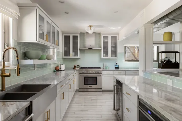 a kitchen with stainless steel appliances granite countertop a stove sink and cabinets