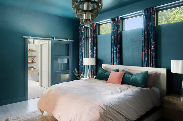 a bedroom with a large bed and a chandelier