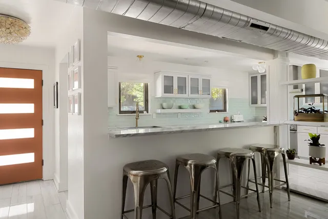 a kitchen with table chairs cabinets and wooden floor