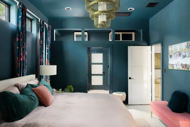 a bedroom with a bed and dresser with mirror