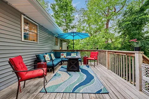 a view of a chair and table in the garden near a lake