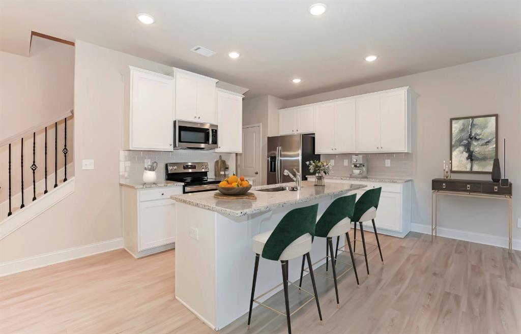 2150 Spring Rush Drive, Unit 127 Buford, GA 30519 - Photo 1 of 15 a kitchen with a sink a microwave a counter top space and cabinets