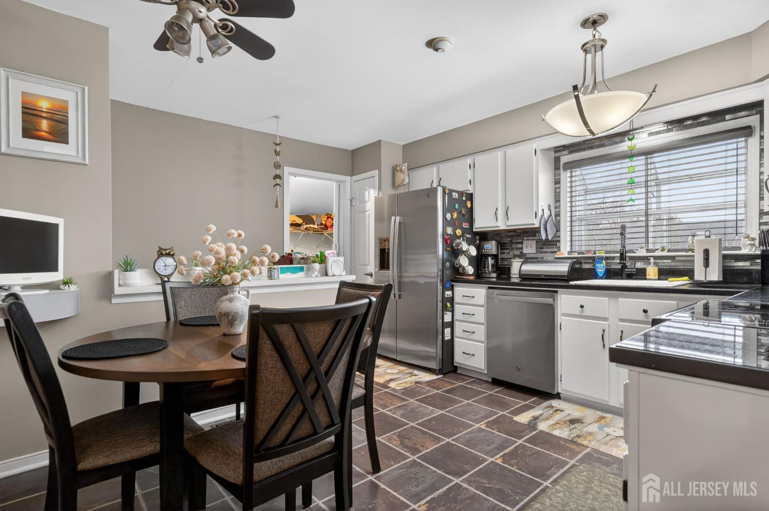 5 Scarborough Road, Unit D Monroe Township, NJ 08831 - Photo 4 of 28 a kitchen with stainless steel appliances kitchen island granite countertop a dining table chairs and a refrigerator