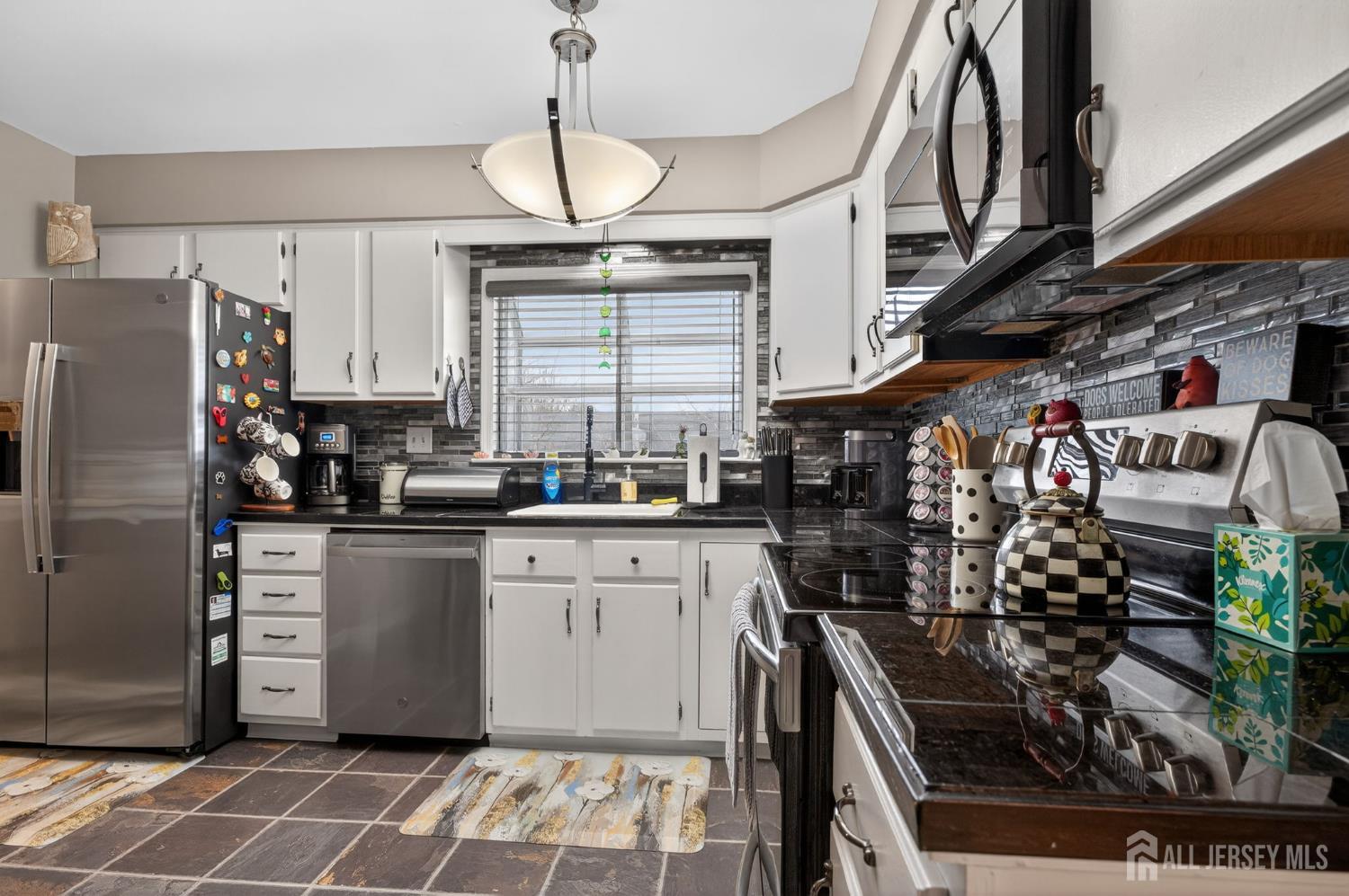 5 Scarborough Road, Unit D Monroe Township, NJ 08831 - Photo 6 of 28 a kitchen with stainless steel appliances granite countertop a stove a sink and a refrigerator