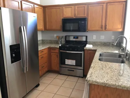 a kitchen with stainless steel appliances granite countertop a refrigerator stove and microwave