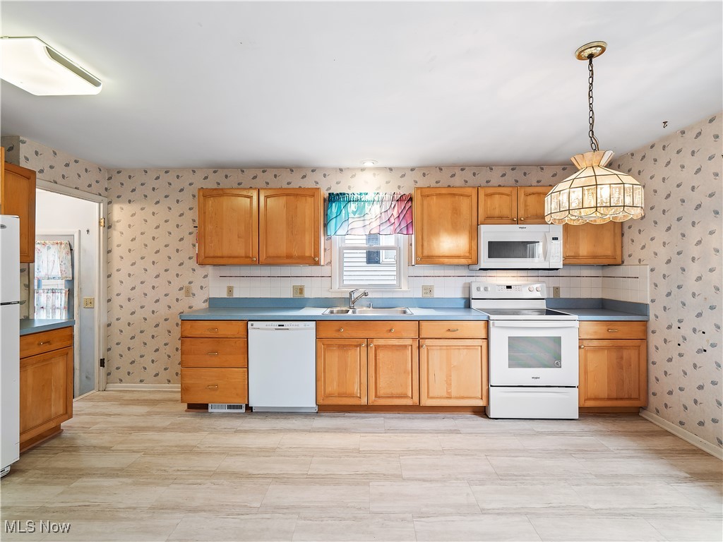 23812 Knickerbocker Road Bay Village, OH 44140 - Photo 11 of 31 Kitchen featuring hanging light fixtures, white appliances, and sink