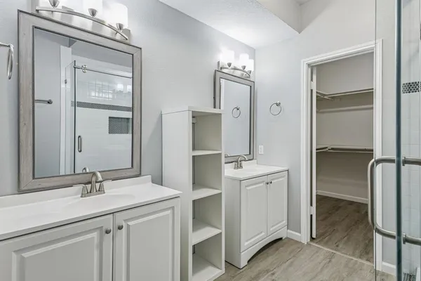 a bathroom with a double vanity sink mirror and shower