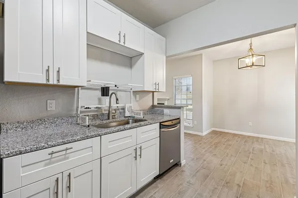 a kitchen with kitchen island granite countertop white cabinets and sink