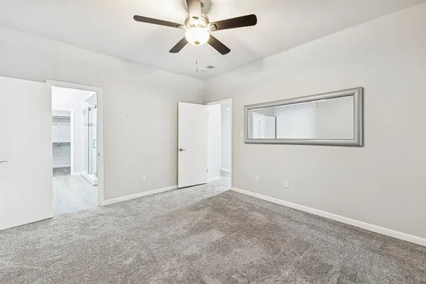 a view of an empty room with a ceiling fan