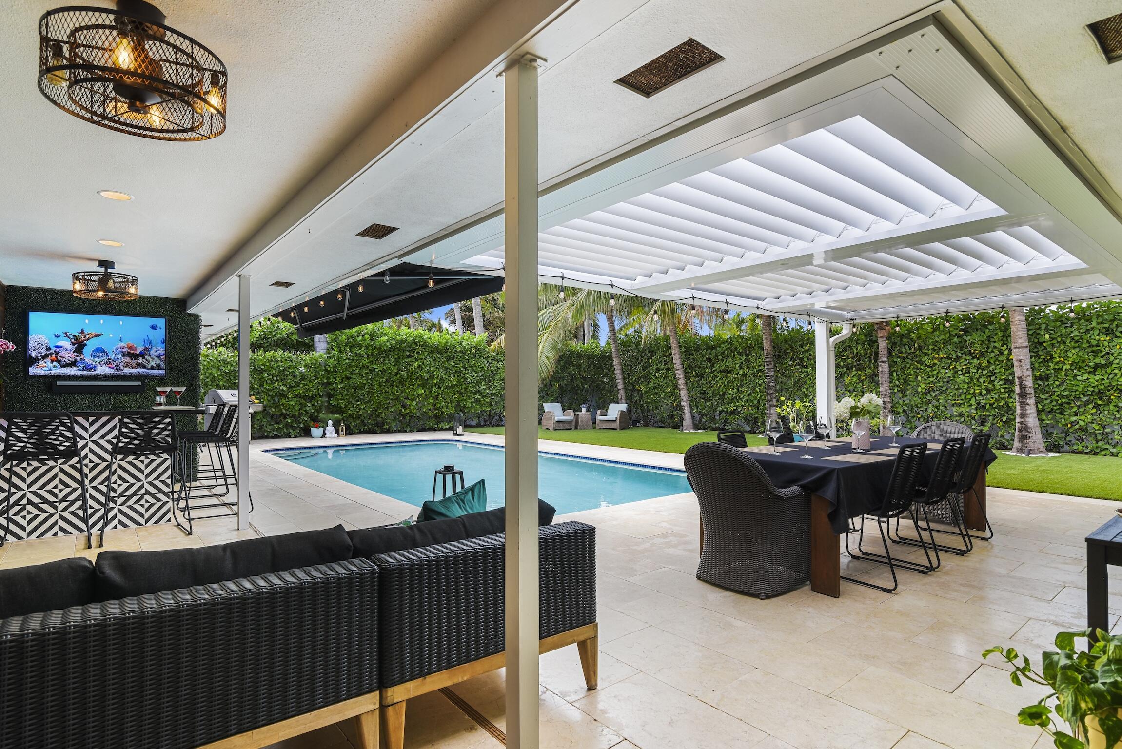 3481 Northeast 31st Avenue Lighthouse Point, FL 33064 - Photo 1 of 33 a view of a patio with a dining table and chairs