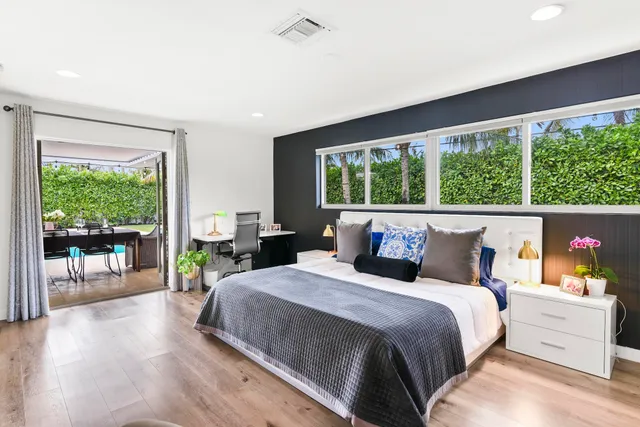 a bedroom with a bed and large windows