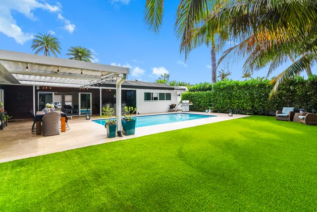 a view of a patio with table and chairs potted plants and palm tree