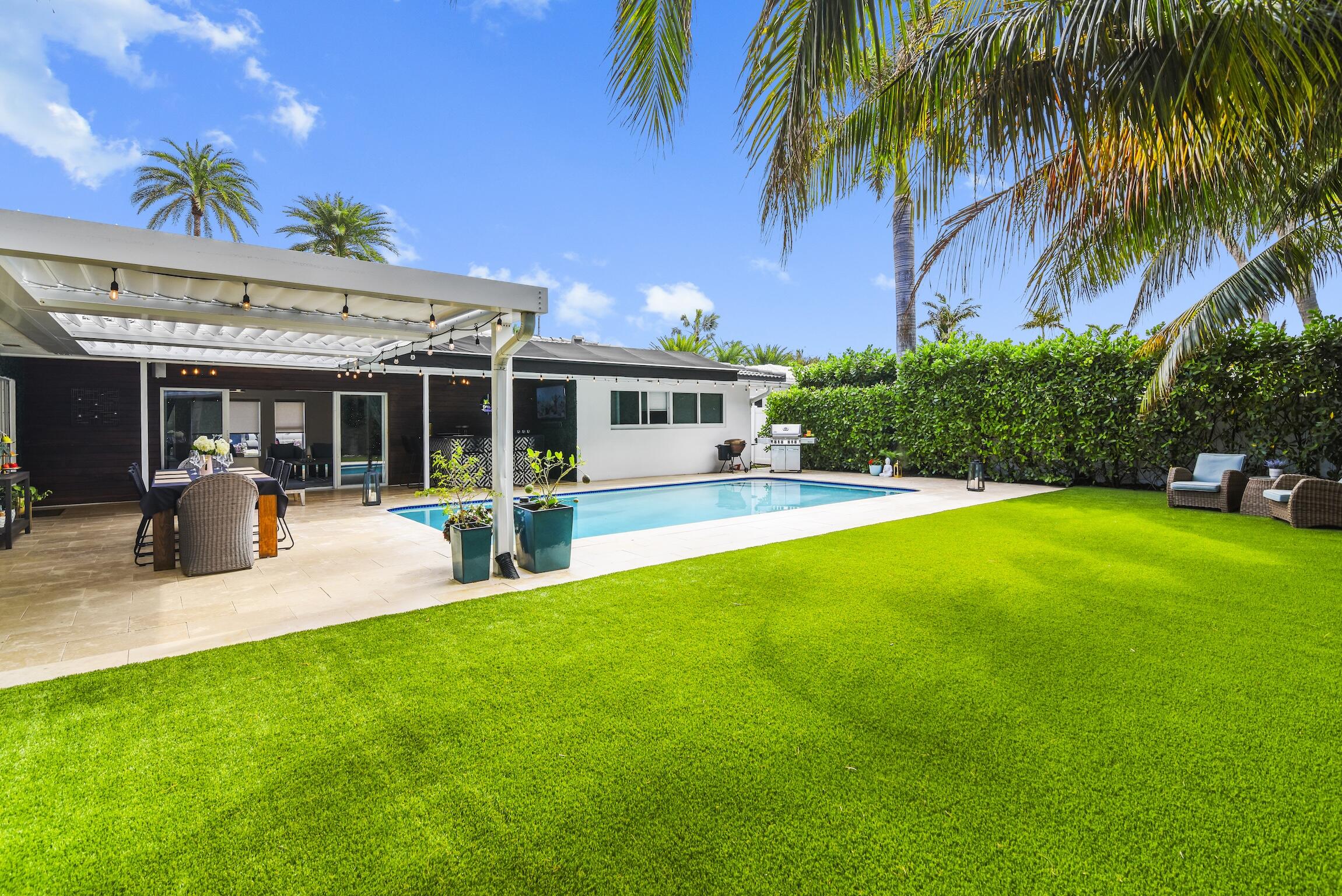 3481 Northeast 31st Avenue Lighthouse Point, FL 33064 - Photo 17 of 33 a view of a patio with table and chairs potted plants and palm tree