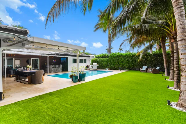 a view of a house with a swimming pool and sitting area