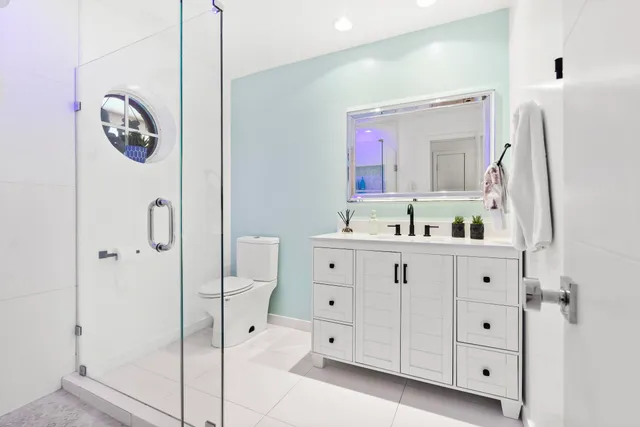 a bathroom with a double vanity sink mirror and toilet