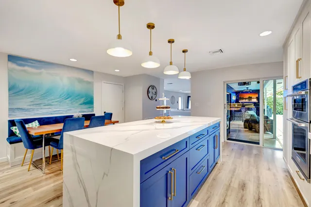 a kitchen with stainless steel appliances kitchen island granite countertop wooden cabinets and a stove