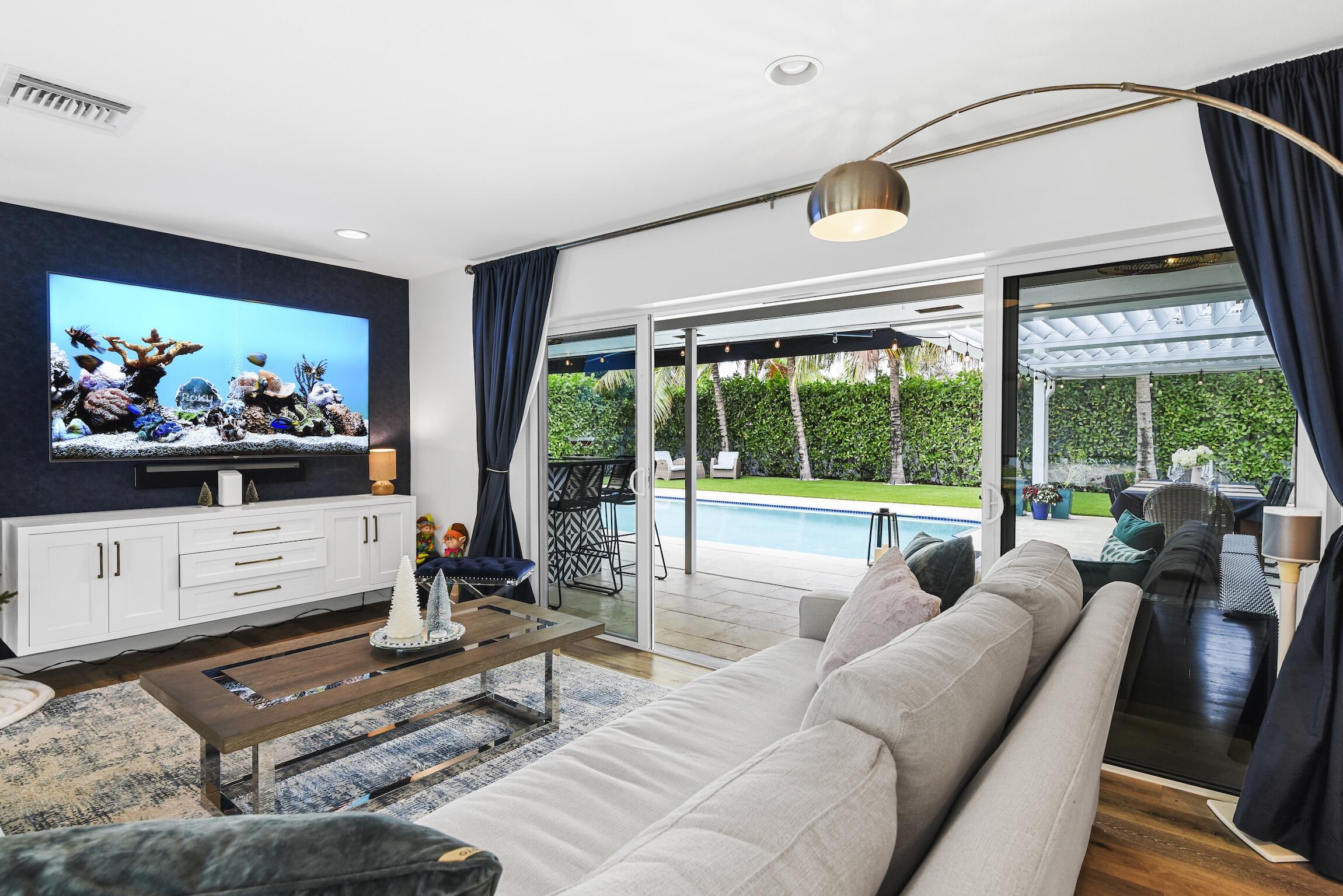 3481 Northeast 31st Avenue Lighthouse Point, FL 33064 - Photo 7 of 33 a living room with furniture a flat screen tv and floor to ceiling window