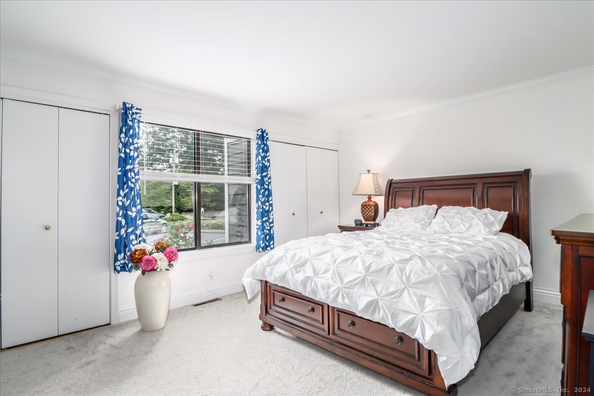 22 Olcott Way, Unit 22 Ridgefield, CT 06877 - Photo 13 of 20 a bed sitting in a bedroom next to a window