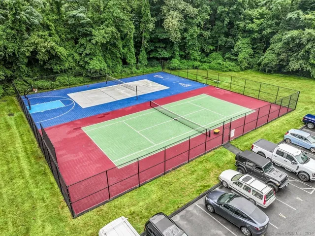 a view of a tennis ground with large trees