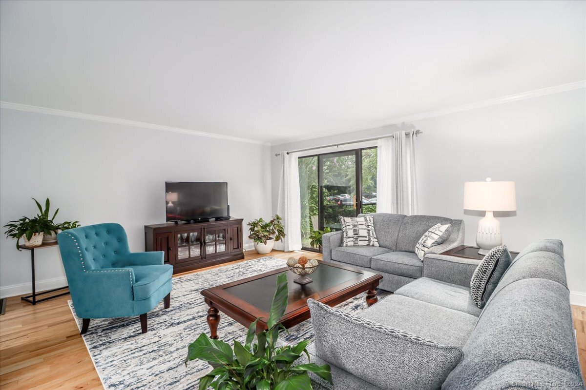 22 Olcott Way, Unit 22 Ridgefield, CT 06877 - Photo 10 of 20 a living room with furniture a flat screen tv and a large window