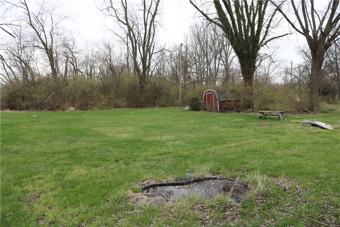 3185 Stop 8 Road Dayton, OH 45414 - Photo 7 of 10 Expansive green space featuring mature trees and a versatile shed, perfect for outdoor living.