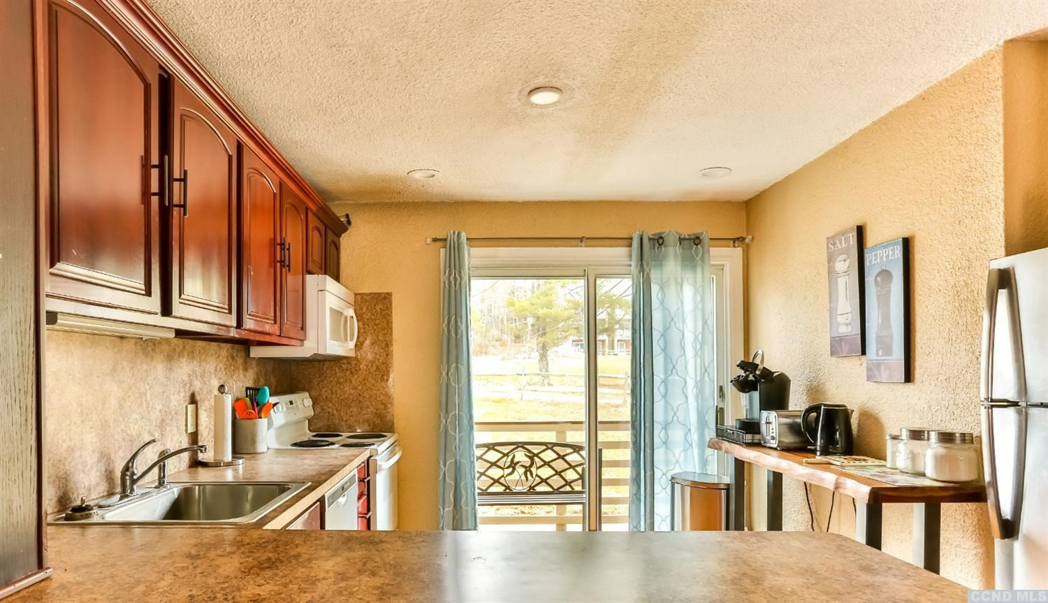 13 Scribner Hollow Road, Unit B1 Hunter, NY 12442 - Photo 13 of 37 a kitchen with stainless steel appliances granite countertop a stove a sink and a refrigerator with wooden floor