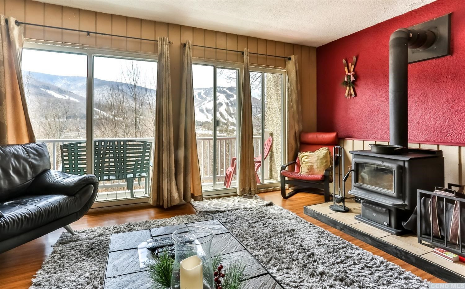 13 Scribner Hollow Road, Unit B1 Hunter, NY 12442 - Photo 7 of 37 a living room with furniture a flat screen tv and a floor to ceiling window