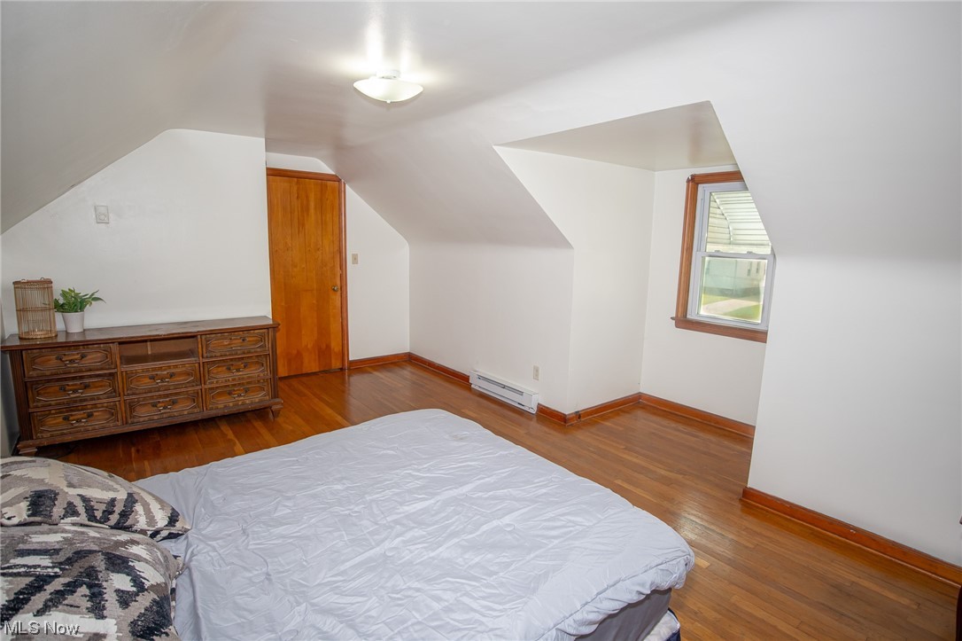 8202 Snow Road Parma, OH 44129 - Photo 20 of 29 Bedroom with light hardwood flooring, baseboard heating, and lofted ceiling
