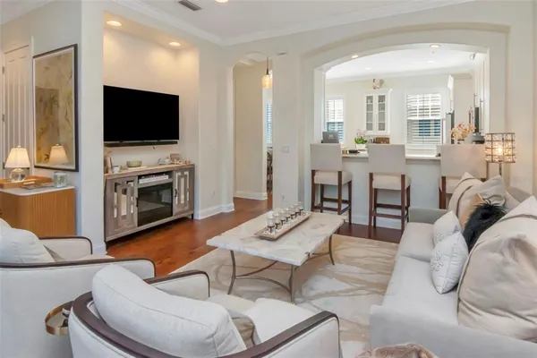 a dining room with furniture a chandelier and wooden floor