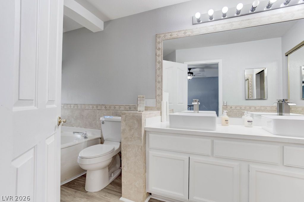 1 Rising Sun Court Henderson, NV 89074 - Photo 33 of 47 Dual vessel sinks and a tiled vanity provide ample space in this bright bathroom.