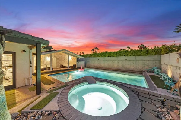 an aerial view of a house with swimming pool and outdoor seating