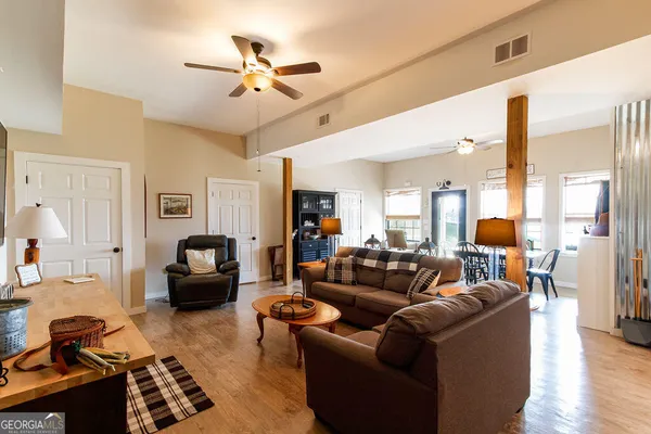 a living room with furniture kitchen view and a chandelier