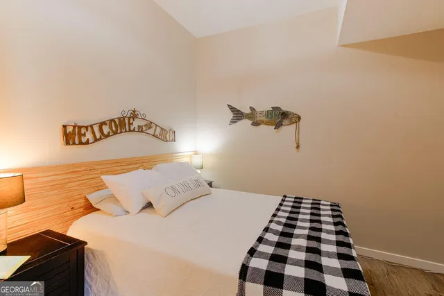 a bedroom with a bed and a black white checkered floor