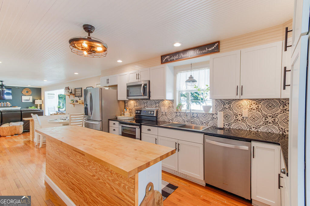 81 Docks Hook Lane Georgetown, GA 39854 - Photo 6 of 33 a kitchen with stainless steel appliances granite countertop a stove top oven a sink dishwasher and white cabinets with wooden floor