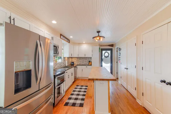 a kitchen with stainless steel appliances granite countertop a refrigerator and a stove top oven