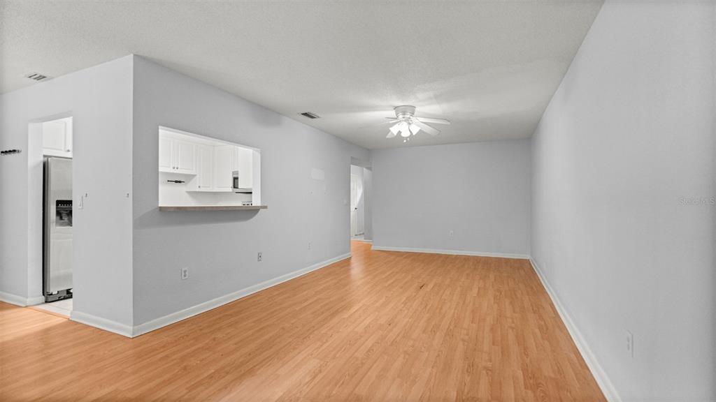 501 Southwest 75th Street, Unit B5 Gainesville, FL 32607 - Photo 6 of 38 an empty room with wooden floor and chandelier fan