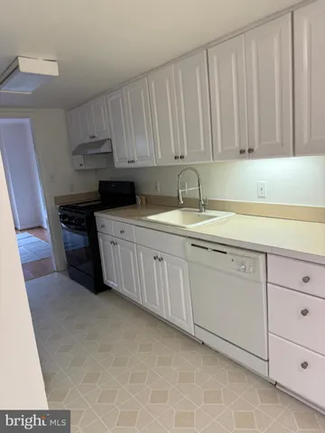 a kitchen with stainless steel appliances granite countertop a sink a stove and cabinets