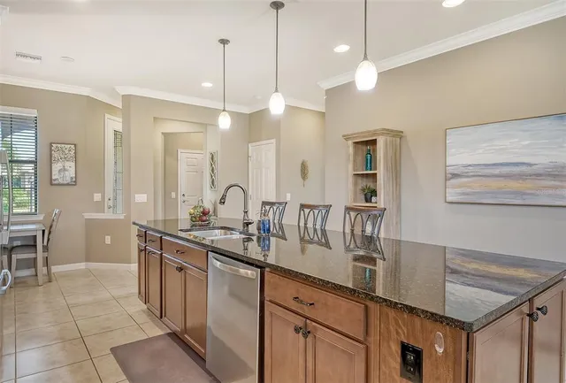 a kitchen with kitchen island granite countertop a sink a counter top space and living room view