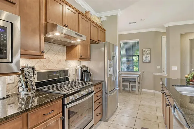 a kitchen with granite countertop a stove chairs and entryway