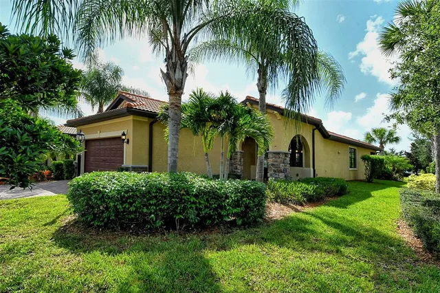 a view of a house with a yard and palm trees