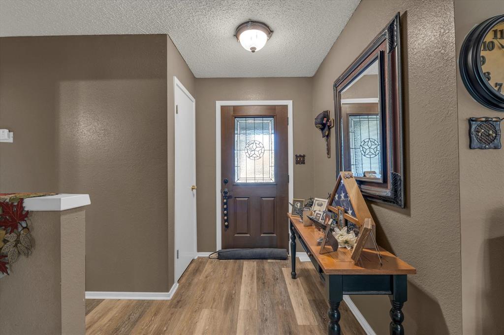 107 Fort Graham Circle Waco, TX 76705 - Photo 12 of 39 Foyer featuring a textured wall, wood finished floors, and a textured ceiling